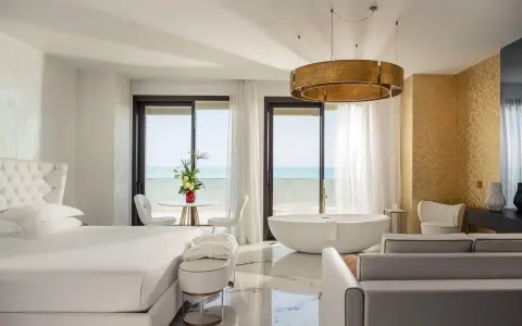 Lussuosa camera con vista mare, perfetta per un soggiorno in un b&b Riviera Romagnola. Letto king, vasca freestanding e arredi eleganti.