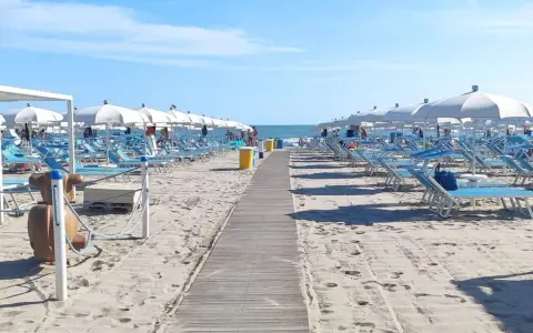 Spiaggia di Misano Adriatico: file di lettini e ombrelloni bianchi pronti per accogliere i bagnanti. Cosa vedere? Il mare azzurro e la sabbia dorata!
