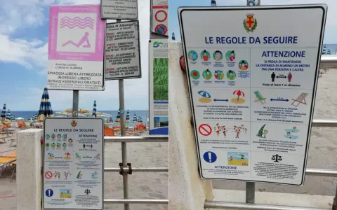 Cartelli informativi su una spiaggia libera attrezzata con regole di distanziamento e norme di comportamento.