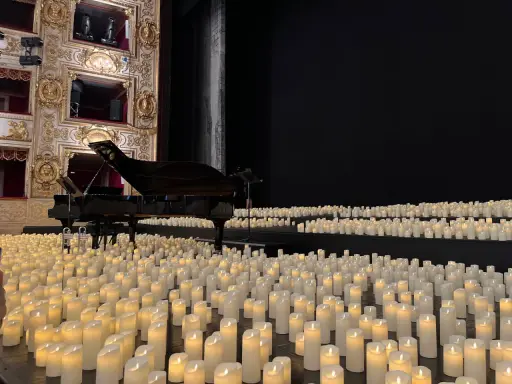 Un pianoforte su un palco ricoperto di candele, un'atmosfera magica di candlelight a Rimini.