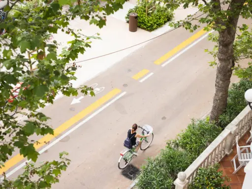 Una donna in bicicletta percorre il lungomare di San Mauro Mare, su una pista ciclabile ben segnalata.