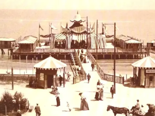 Il primo stabilimento balneare in Italia, un molo con tende a strisce, cabine e gente che passeggia.
