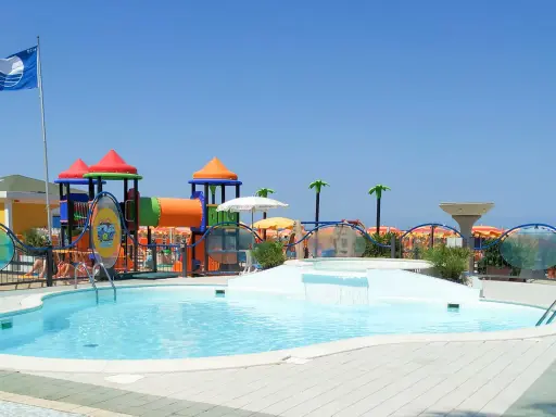 Piscina con scivolo e giochi acquatici in una giornata di sole a Cattolica, Emilia Romagna.