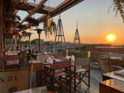 Tavoli apparecchiati in un ristorante con vista sul tramonto a Rimini. Un'atmosfera perfetta per gustare i sapori dei ristoranti romagnoli.