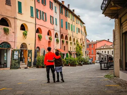 Coppia abbracciata in una strada con case colorate, un assaggio dei paesi belli vicino Ravenna.
