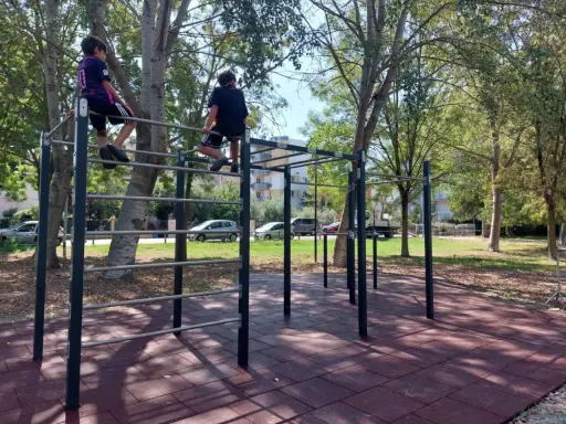 Bambini si arrampicano su una struttura per esercizi all'aperto nel parco Briolini a Rimini.