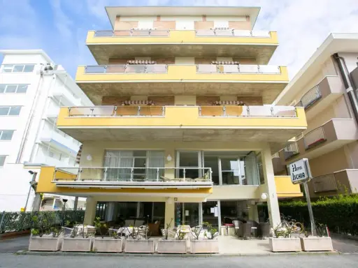 Hotel Ischia a Rimini Marebello, con le sue terrazze gialle e le finestre luminose, pronto ad accogliere i suoi ospiti per una vacanza al mare.