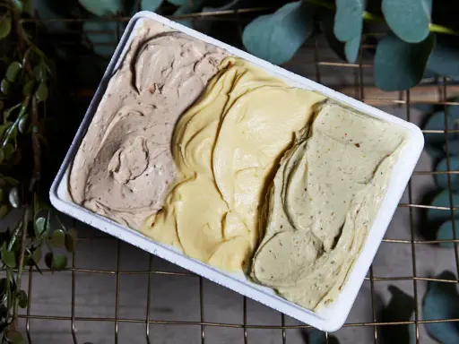 Tre gusti di gelato artigianale, tra cui la romana, in una vaschetta bianca.