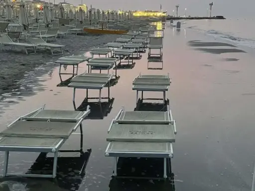 Lettini da spiaggia sommersi dall'acqua a Riccione, con la bassa marea che ha lasciato il segno.