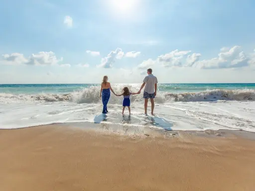 Famiglia felice sulla riviera romagnola con bambini, godendosi le onde del mare.