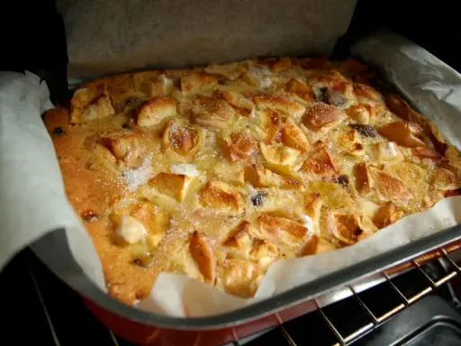 Bustrengo riminese appena sfornato, con mele dorate e zucchero croccante. Un dolce della tradizione romagnola.