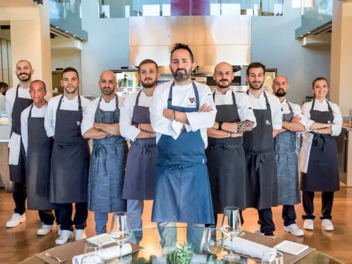 Il team di chef posa con orgoglio, pronto a servire esperienze culinarie d'eccellenza nei ristoranti stellati di Rimini.