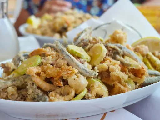 Fritto misto di pesce e verdure, un'ottima idea per cosa mangiare a Riccione. Croccante e saporito, perfetto con una caraffa di vino bianco.