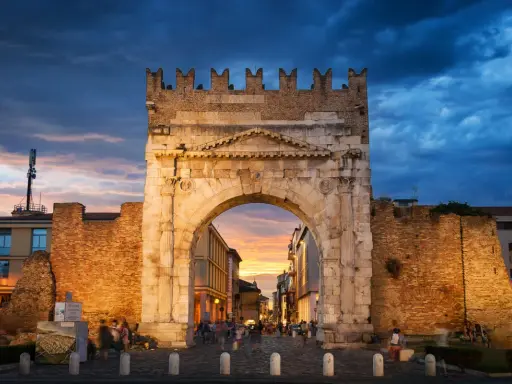 Arco d'Augusto a Rimini al tramonto, con il suo skyline suggestivo e le nuvole drammatiche.