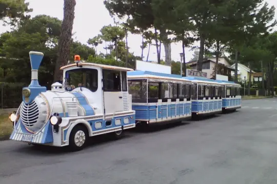 Il trenino turistico di Cervia, bianco e azzurro, attende passeggeri per un giro tra i pini e le case.