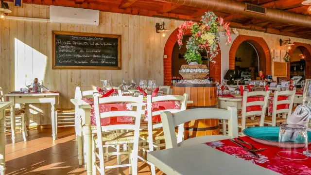 Interno di un ristorante di carne a Rimini centro, con tavoli apparecchiati e un menu scritto a mano.
