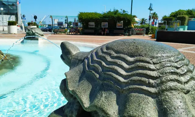 Fontana con tartarughe di pietra, un'idea di cosa visitare a Cattolica. Acqua azzurra e scorci estivi.