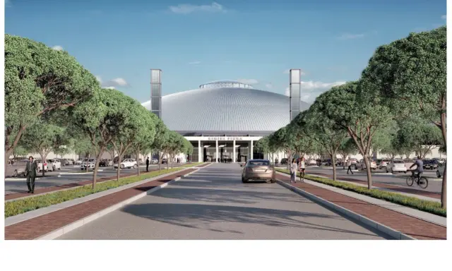 Ingresso ovest della fiera di Rimini, con viali alberati, parcheggi e un'imponente cupola.