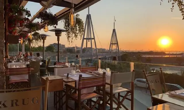 Tavoli apparecchiati in un ristorante con vista sul tramonto a Rimini. Un'atmosfera perfetta per gustare i sapori dei ristoranti romagnoli.