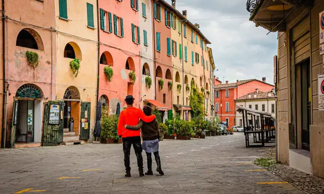 Coppia abbracciata in una strada con case colorate, un assaggio dei paesi belli vicino Ravenna.