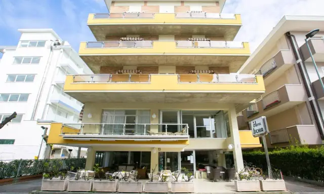 Hotel Ischia a Rimini Marebello, con le sue terrazze gialle e le finestre luminose, pronto ad accogliere i suoi ospiti per una vacanza al mare.