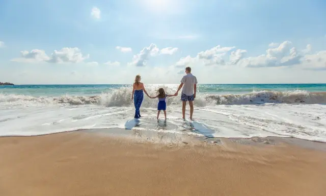 Famiglia felice sulla riviera romagnola con bambini, godendosi le onde del mare.