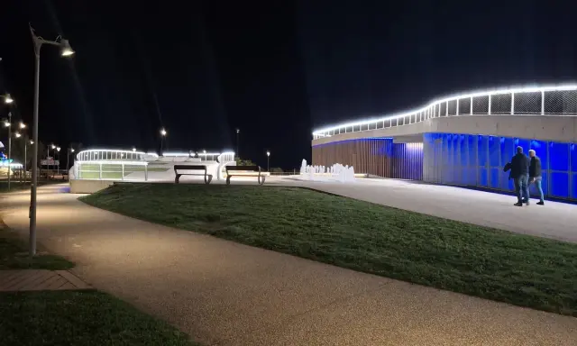 Passeggiata serale a **Piazzale Kennedy Rimini**, con fontane luminose e architettura moderna illuminata.