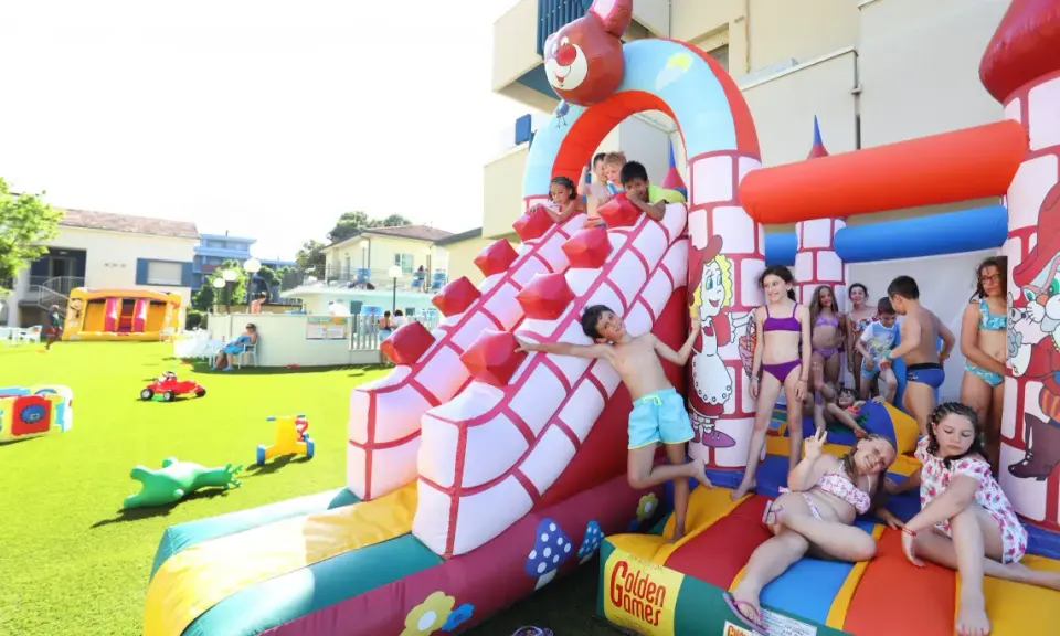Bambini si divertono sulle giostre gonfiabili a Bellaria, scivolando e giocando in un parco acquatico pieno di allegria.