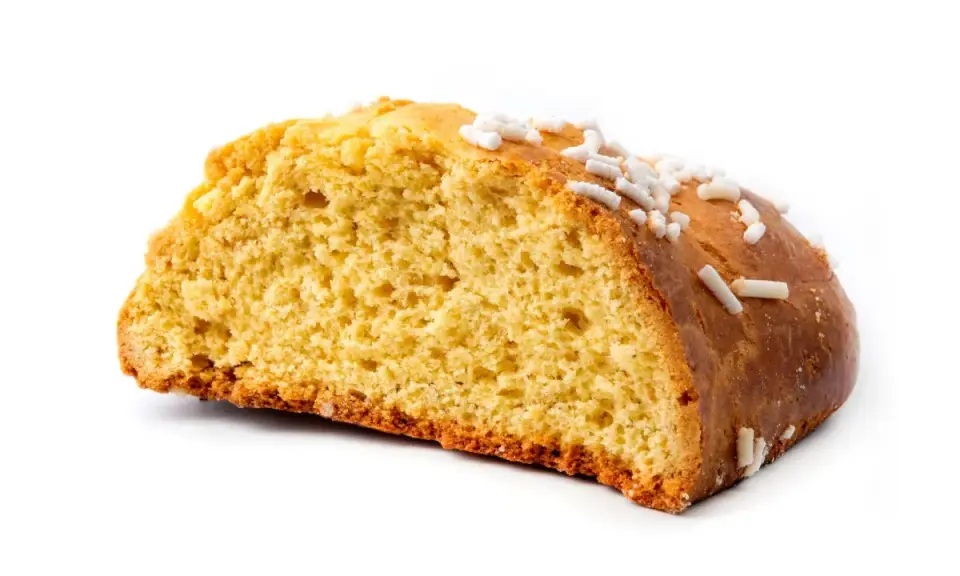 Fetta di ciambella, un dolce tipico romagnolo, con zuccherini bianchi sparsi sulla crosta dorata.