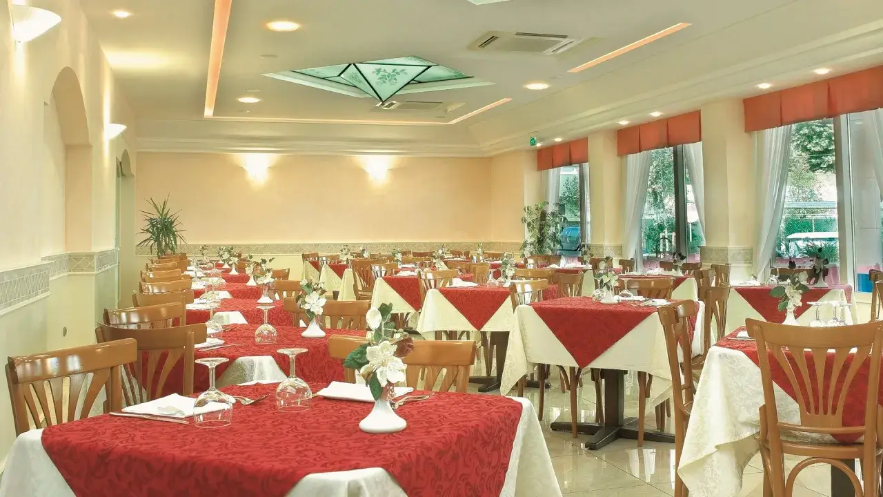 Sala da pranzo elegante con tavoli apparecchiati, ideale per scoprire le recensioni del Hotel Missouri Igea Marina.