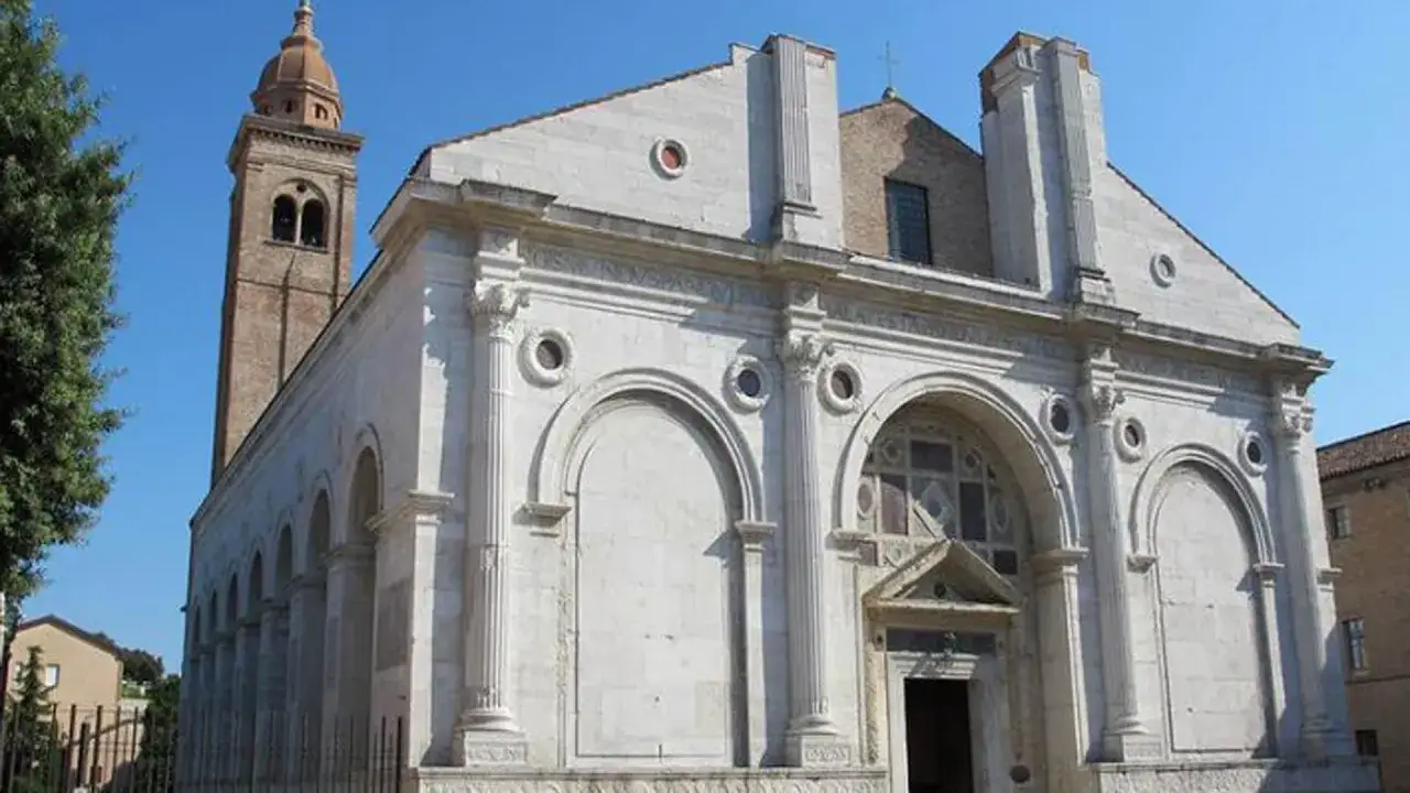 Il Tempio Malatestiano, capolavoro di Leon Battista Alberti, con la sua facciata in marmo bianco e il campanile a mattoni rossi.