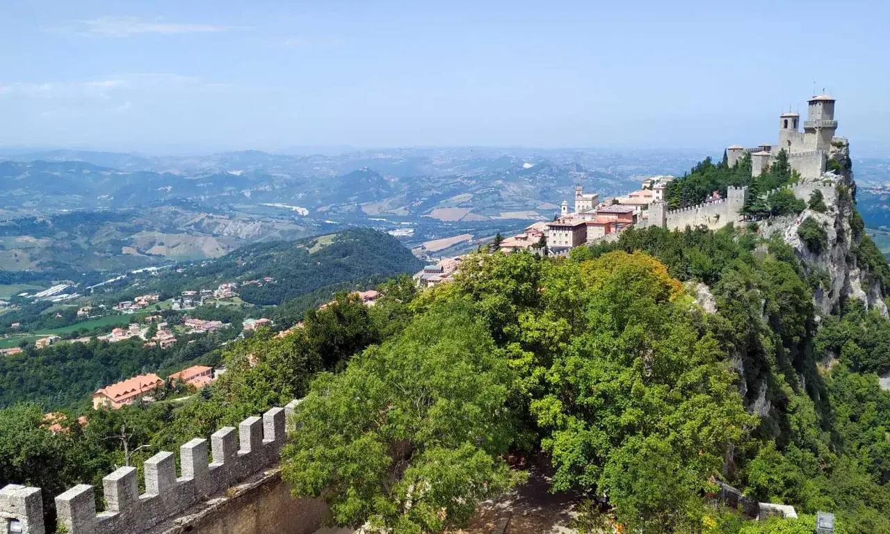 Vista panoramica di San Marino con le sue torri medievali arroccate su una collina, un luogo perfetto per una visita indimenticabile.