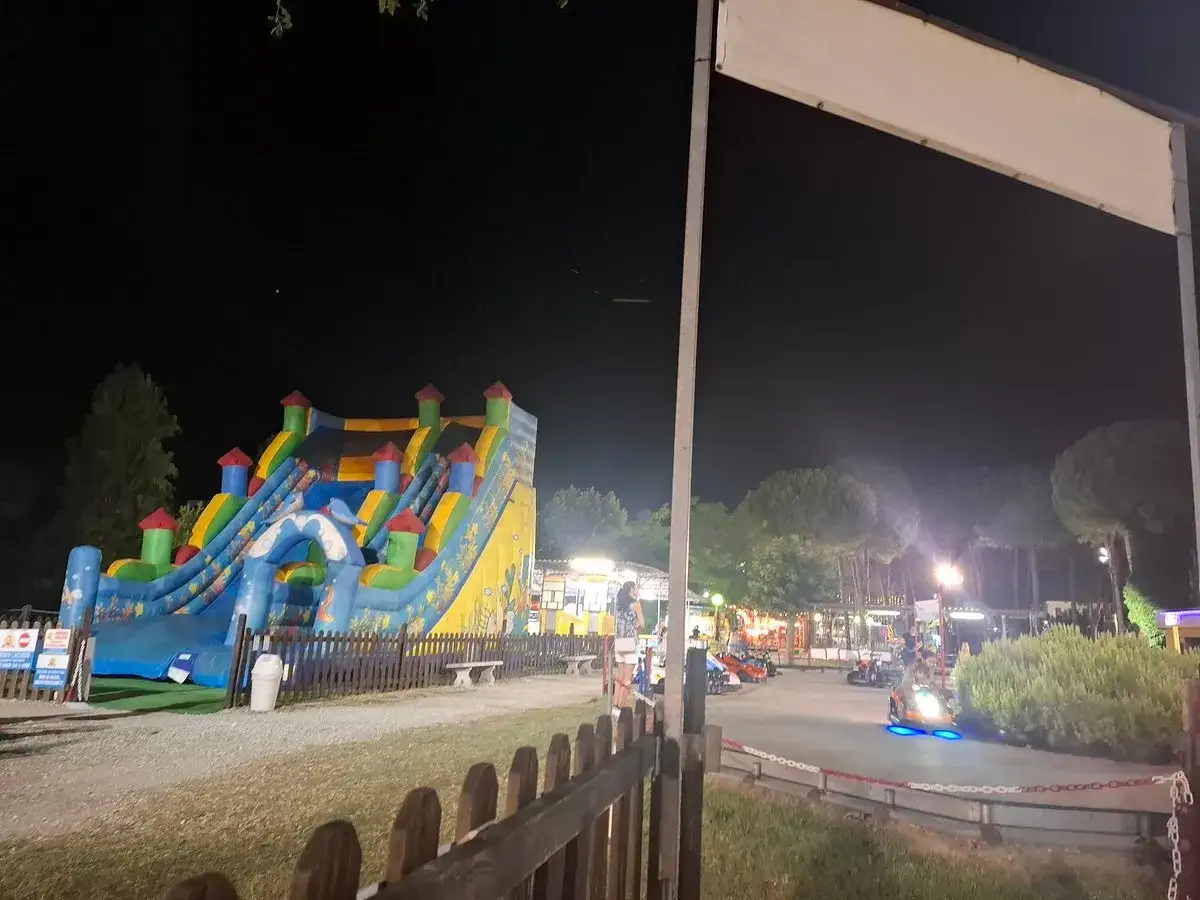 Le giostre di Bellaria di notte: un colorato scivolo gonfiabile e go-kart illuminati creano un'atmosfera magica.