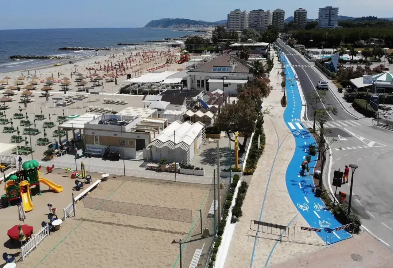 Pista ciclabile blu sul lungomare di Misano Adriatico, con spiaggia, giochi per bambini e ristoranti.