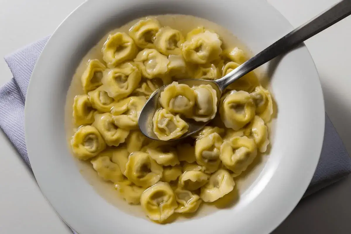 Tortellini in brodo, un classico da provare per capire cosa mangiare a Ravenna. Un piatto caldo e confortante.