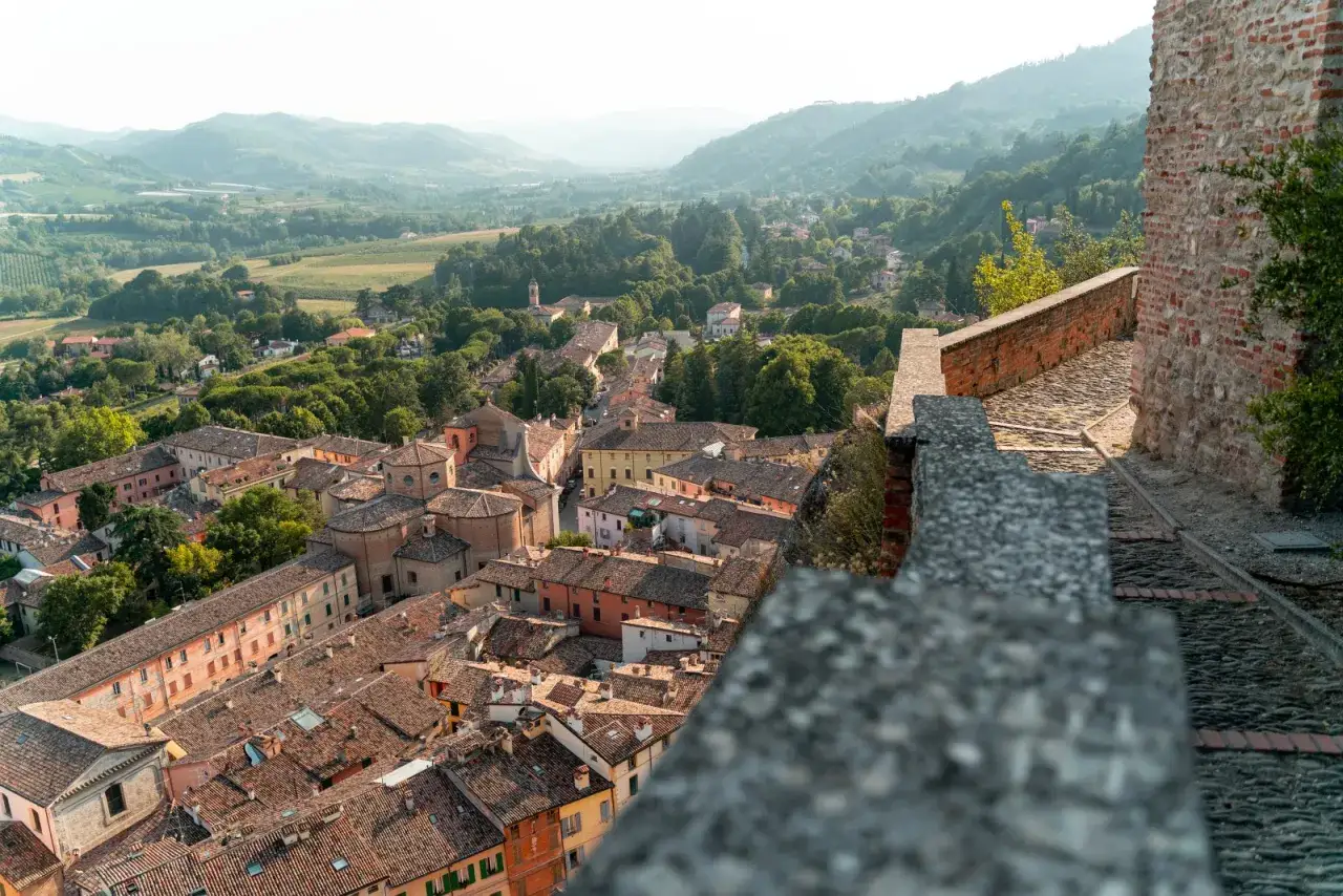 Panoramica di borghi medievali vicino a Cesenatico, con tetti in cotto e colline verdi sullo sfondo.