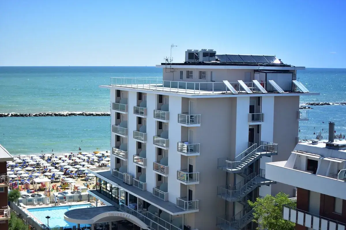 Vista mare dal hotel Faro San Mauro Mare. Spiaggia attrezzata, piscina e mare azzurro sotto un cielo limpido.