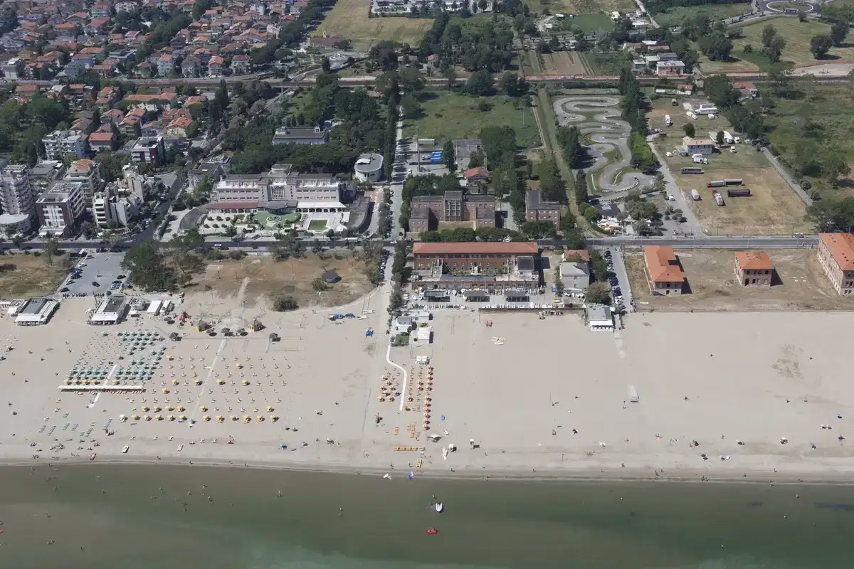 Vista aerea di Riccione: spiaggia affollata, hotel, case e un circuito per go-kart. Ecco cosa vedere a Riccione per una vacanza indimenticabile.