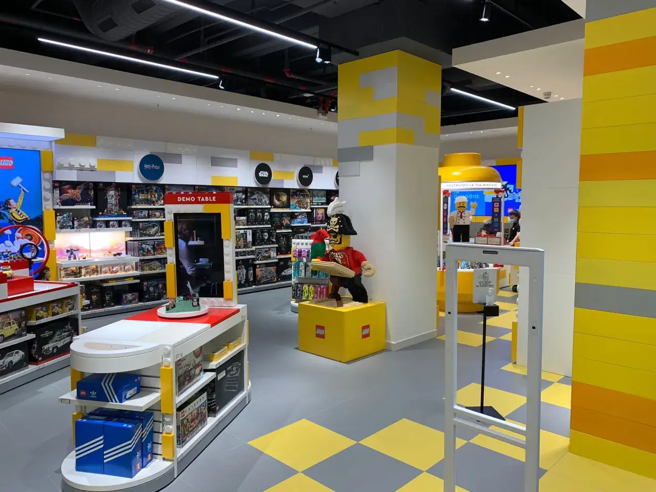 Negozio LEGO con scaffali pieni di set, un personaggio pirata LEGO e un'area per costruire minifigure. Sembra un posto perfetto per trovare i tuoi LEGO le Befane preferiti!