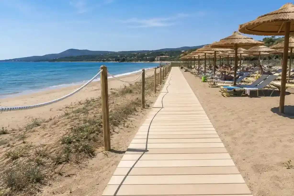 Passerella in legno su una bellissima spiaggia di Rimini, con ombrelloni e lettini pronti per accogliere i bagnanti.