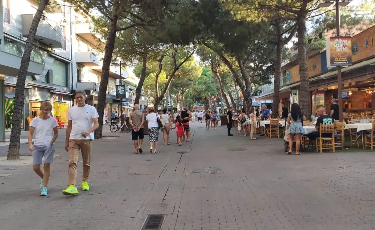 Passeggiata serale nel riccione centro, tra negozi e ristoranti all'aperto sotto i pini.