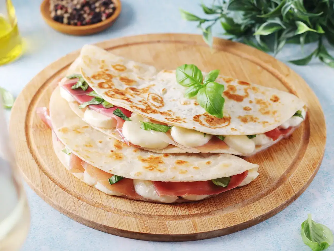 Ecco come si farciscono le piadine: prosciutto, mozzarella filante e basilico fresco, un ripieno delizioso e semplice.