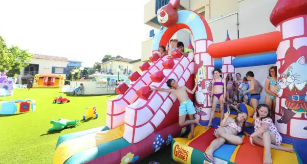 Bambini si divertono sulle giostre gonfiabili a Bellaria, scivolando e giocando in un parco acquatico pieno di allegria.