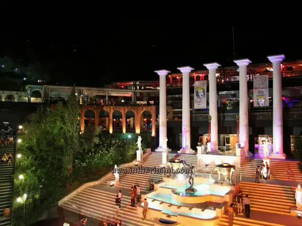 Un'imponente struttura con colonne greche, fontane e scalinate illuminate, pronta ad accogliere la movida delle discoteche Rimini.