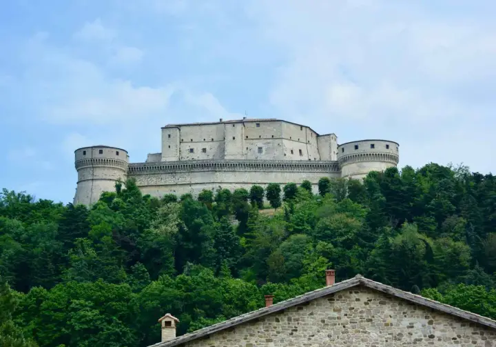 Rocchetta imponente su una collina verdeggiante, un gioiello tra i borghi dell'Emilia Romagna.