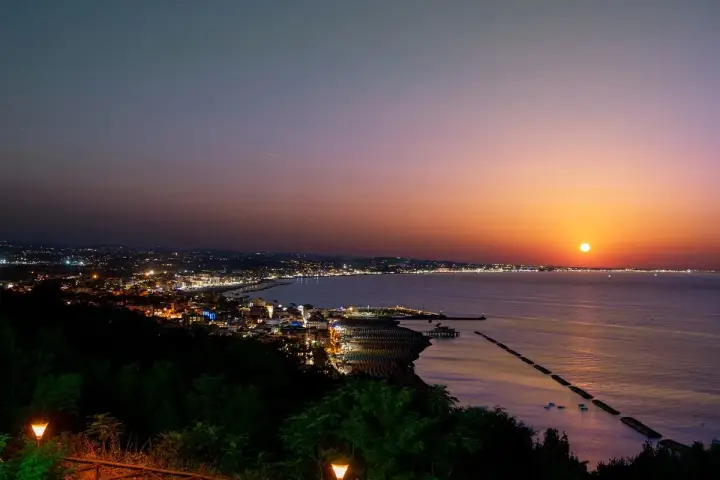 Tramonto su Gabicce Mare. Luci della città accese, un invito a scoprire cosa fare a Gabicce Mare la sera, tra passeggiate sul lungomare e cene vista mare.