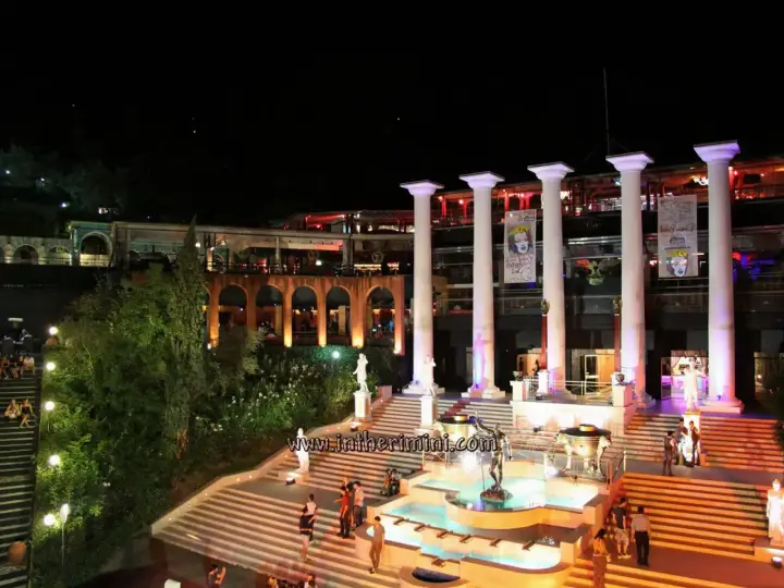 Un'imponente struttura con colonne greche, fontane e scalinate illuminate, pronta ad accogliere la movida delle discoteche Rimini.